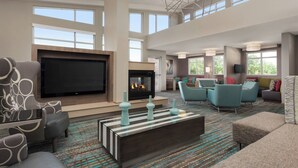 A spacious living room with a large flat-screen TV, a fireplace, and comfortable seating.
