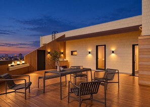 A rooftop terrace with a wooden deck, seating area, and a bar. - SAMHO HOTEL 삼호호텔 (Seoul)