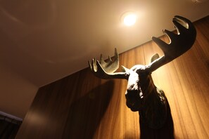 A deer head mounted on a wall with a ceiling light above it. - Vatica Hotel Dongdaemun (Seoul)