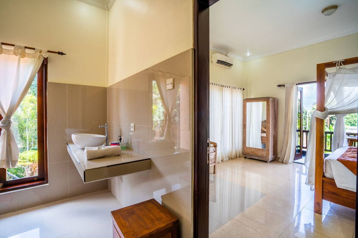 A modern bathroom with a large sink, vanity, and a wooden bench.