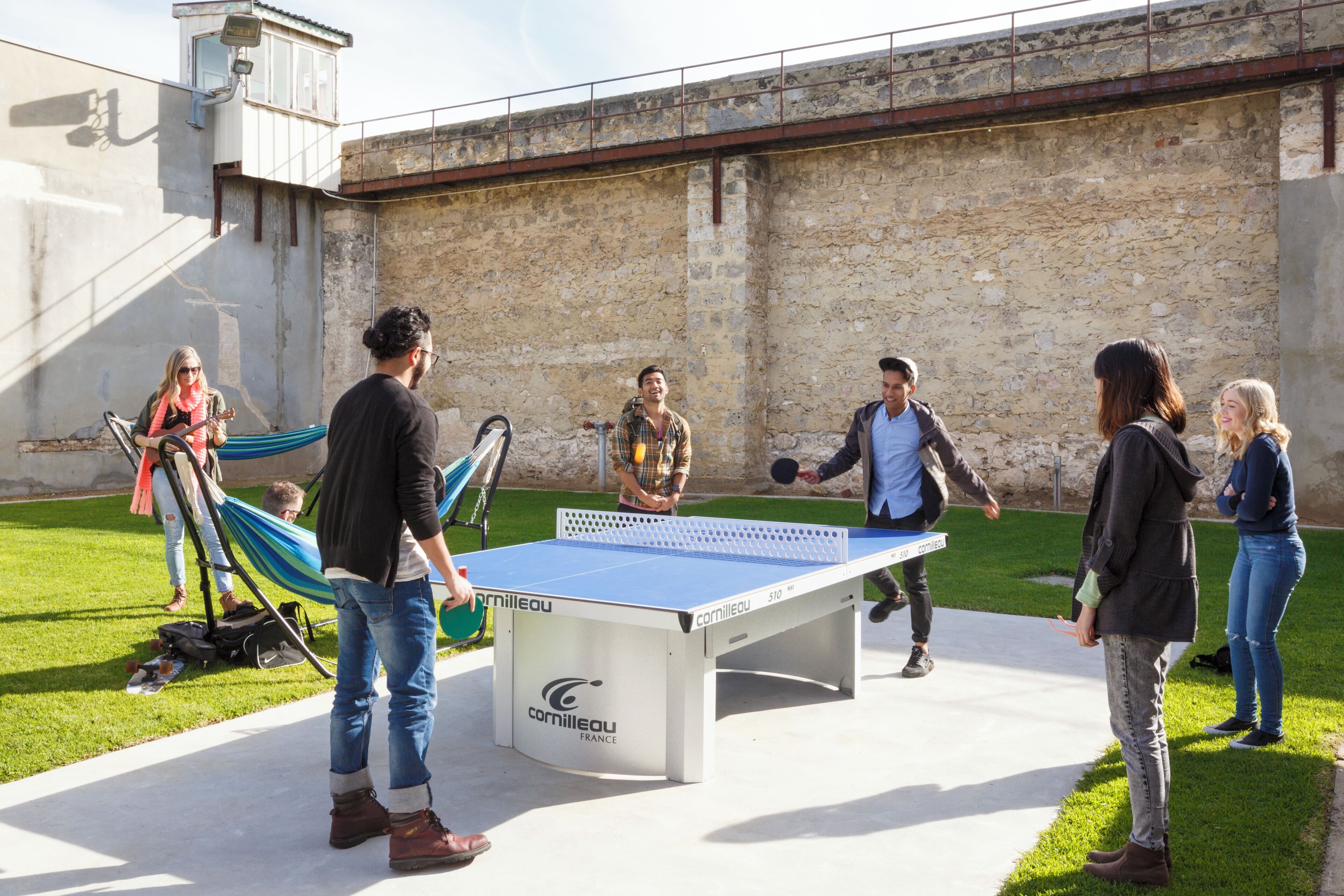 Un gruppo di persone gioca a ping pong all'aperto.