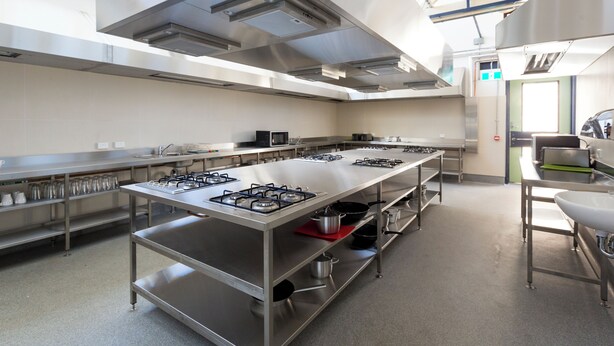 A modern kitchen with stainless steel appliances, a long counter, and ample storage space. - YHA Fremantle Prison (Fremantle)