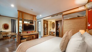 Ett modernt hotellrum med en stor säng, ett skrivbord med en platt-TV, en garderob och ett badrum som syns genom en öppen dörr.