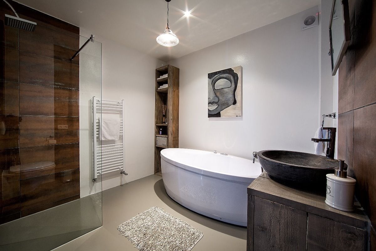 A modern bathroom with a glass shower enclosure, a freestanding bathtub, and a wooden vanity.