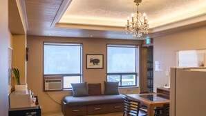 A compact kitchen with a dining area, a sofa, and a chandelier. - YEHADOYE Guest House (Seoul)
