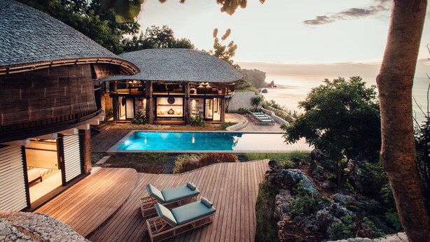 A luxurious villa with a swimming pool, wooden deck, and a view of the sea. - Suarga Padang Padang (Pecatu)