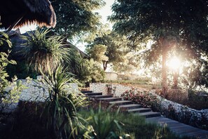 A stone staircase leading up a hill, surrounded by lush greenery and trees. - Suarga Padang Padang (Pecatu)