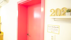 A bright red door with a sign that reads "Save the Earth" and a date and time instruction.
