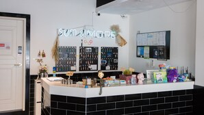 A reception desk with a neon sign reading "SUM & MORE".