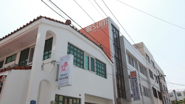 A building with signage for 'Sum Guest House' and 'Mint House'.