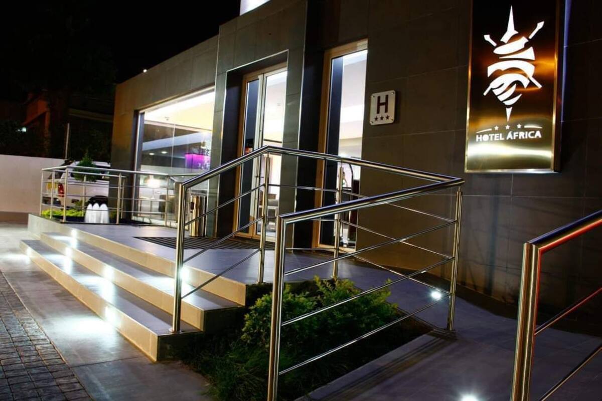 A modern hotel entrance with a glass facade, a metal staircase, and a sign indicating a 3-star rating.