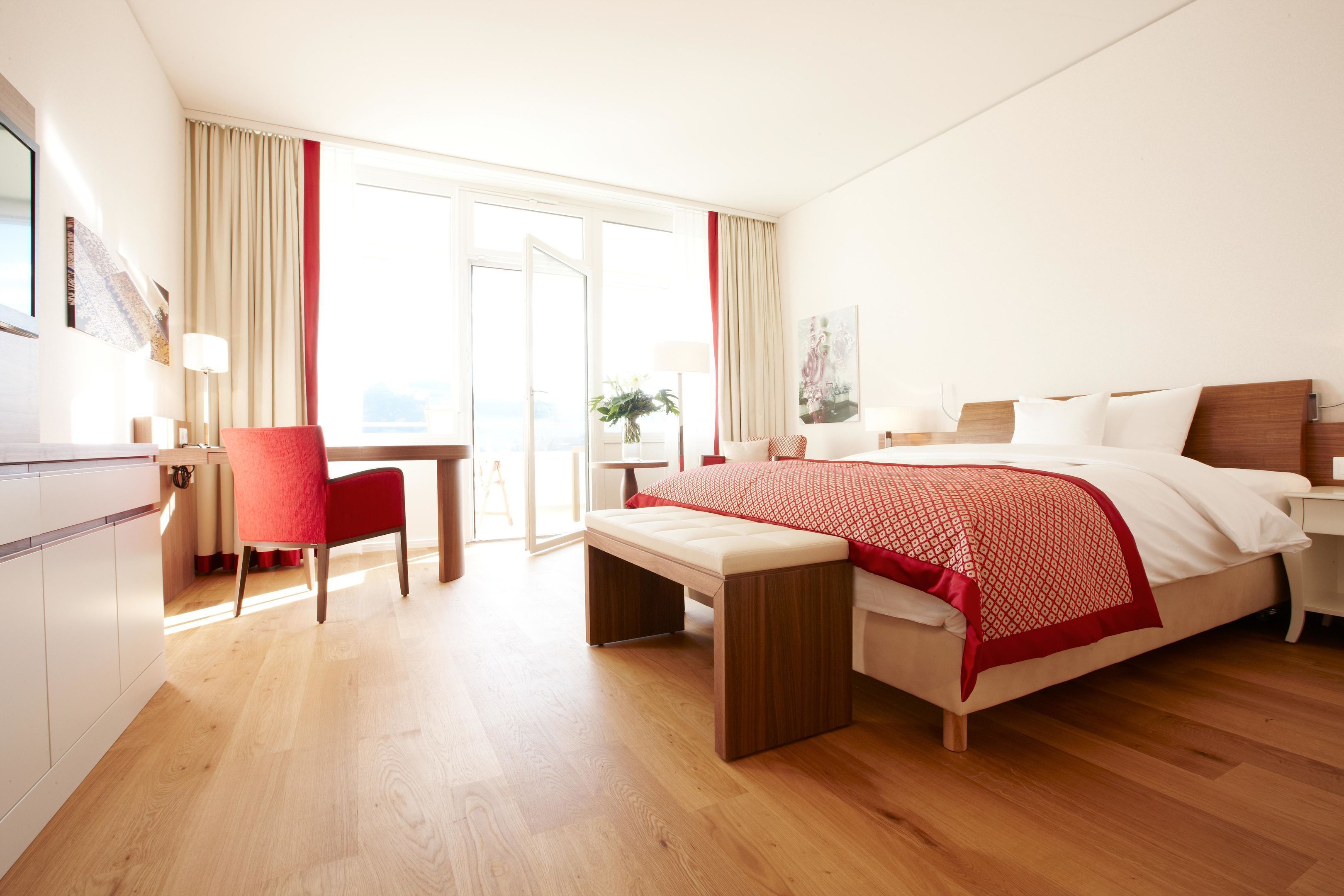 Habitació d'hotel amb un llit, escriptori, cadira i una banca.