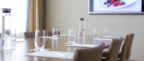 A conference room with a long table, chairs, and water glasses.