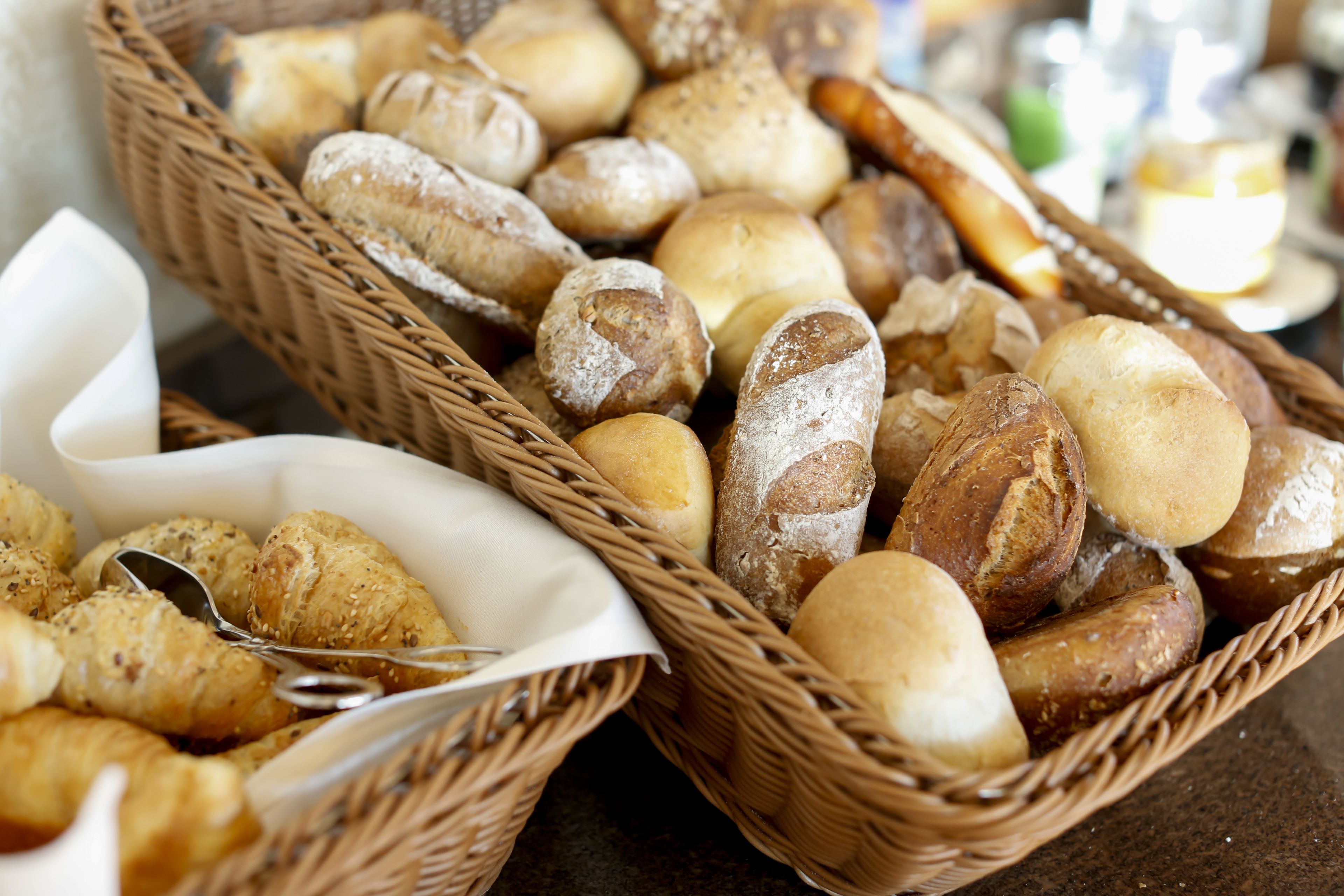 Two wicker baskets filled with various types of bread.