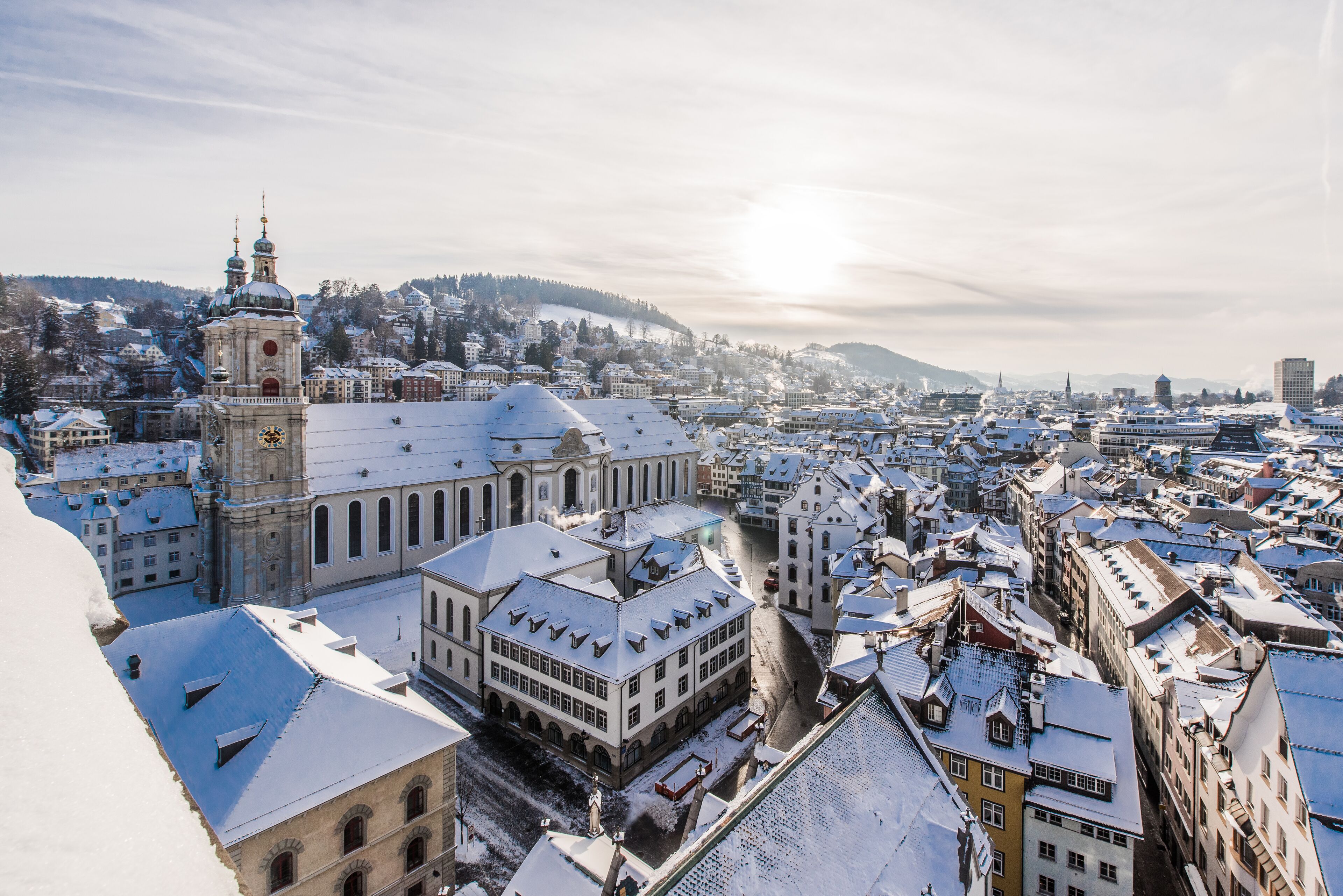 Un paisaje urbano nevado con edificios históricos y una iglesia destacada con un campanario.
