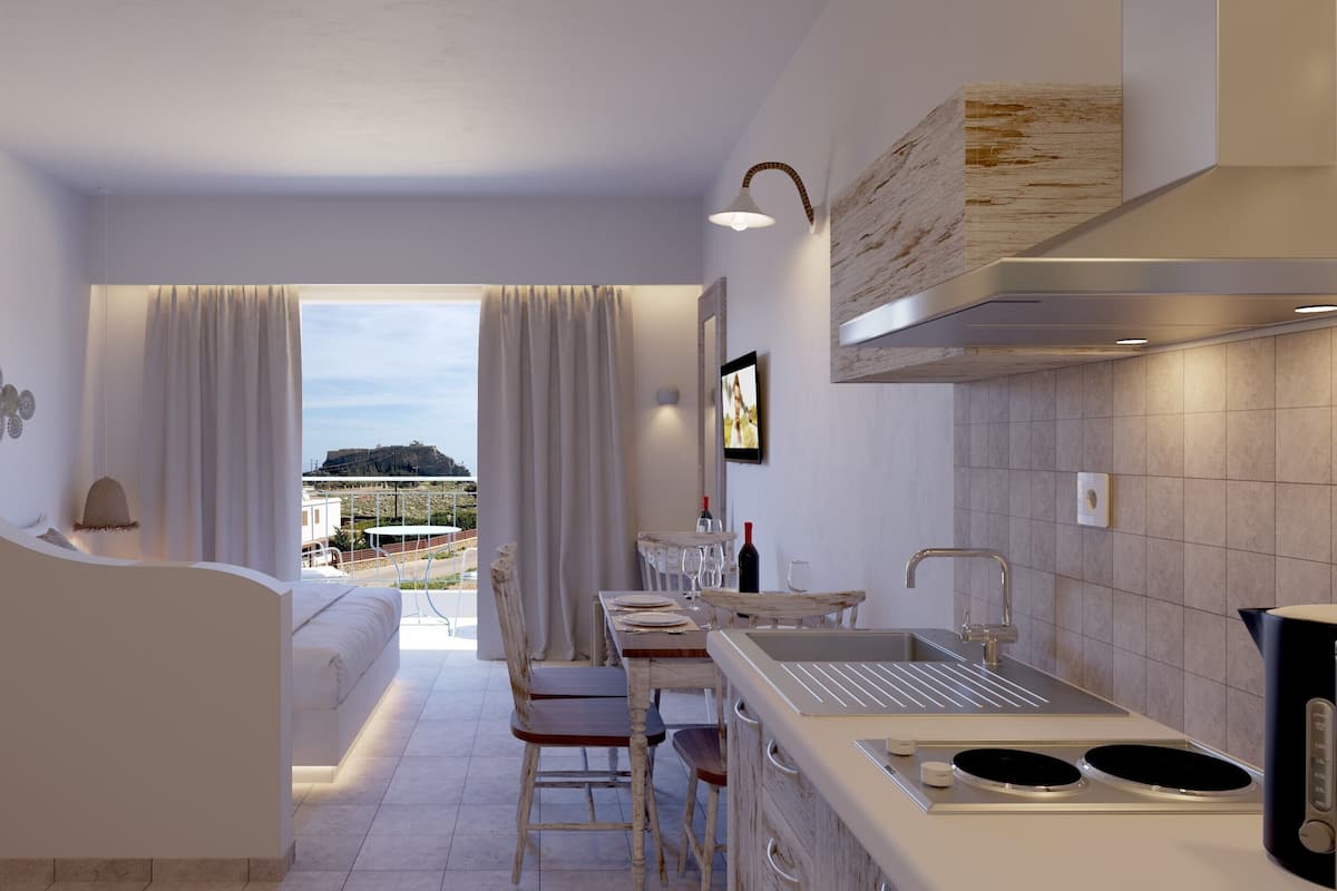 Una cocina moderna con vistas al campo, un comedor con mesa y sillas, y un sofá en la sala de estar.