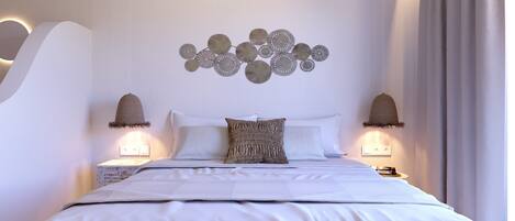 Un dormitorio moderno con una cama grande, dos lámparas fijadas a la pared y un adorno decorativo sobre la cama.