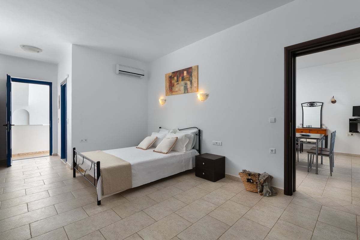 Un dormitorio con cama, mesita de noche y un cuadro en la pared.