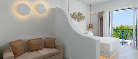 A modern hotel room with a sofa, a bed, a wall-mounted light fixture, and a balcony with a view.