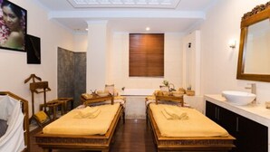 A room with two wooden beds, a large mirror, a sink, and a ceiling light fixture. - The Batik Hotel (Medan)