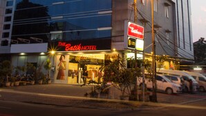 A modern hotel with a glass facade, a visible sign for "The Batik Hotel," and a street view with parked cars and a sidewalk. - The Batik Hotel (Medan)