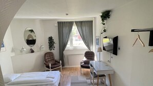 A compact hotel room with two single beds, a desk, a chair, a TV, and a radiator. - Fleninge Classic Motel (Fleninge)
