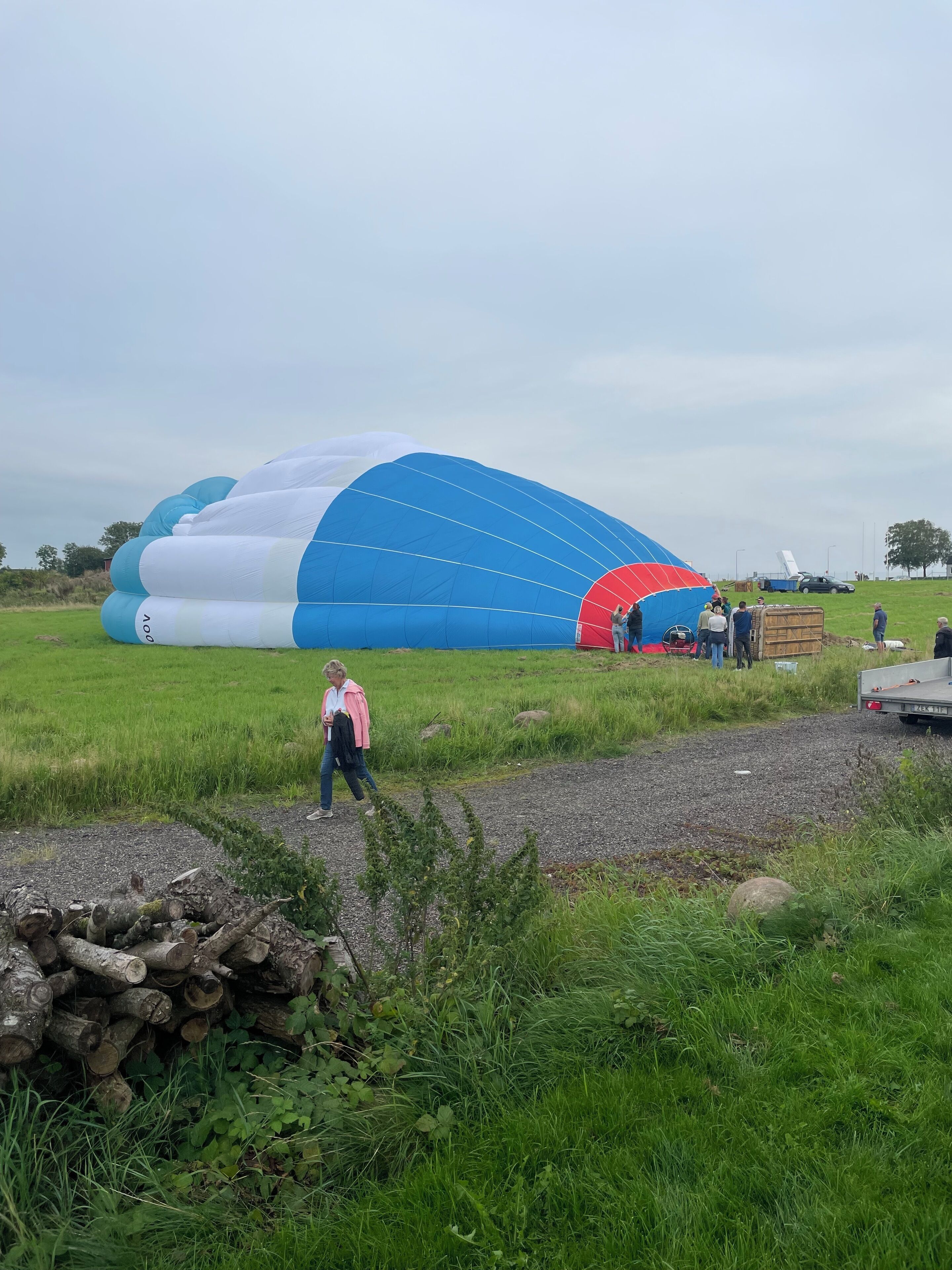 A large blue and white inflatable structure in an open field with people around it.