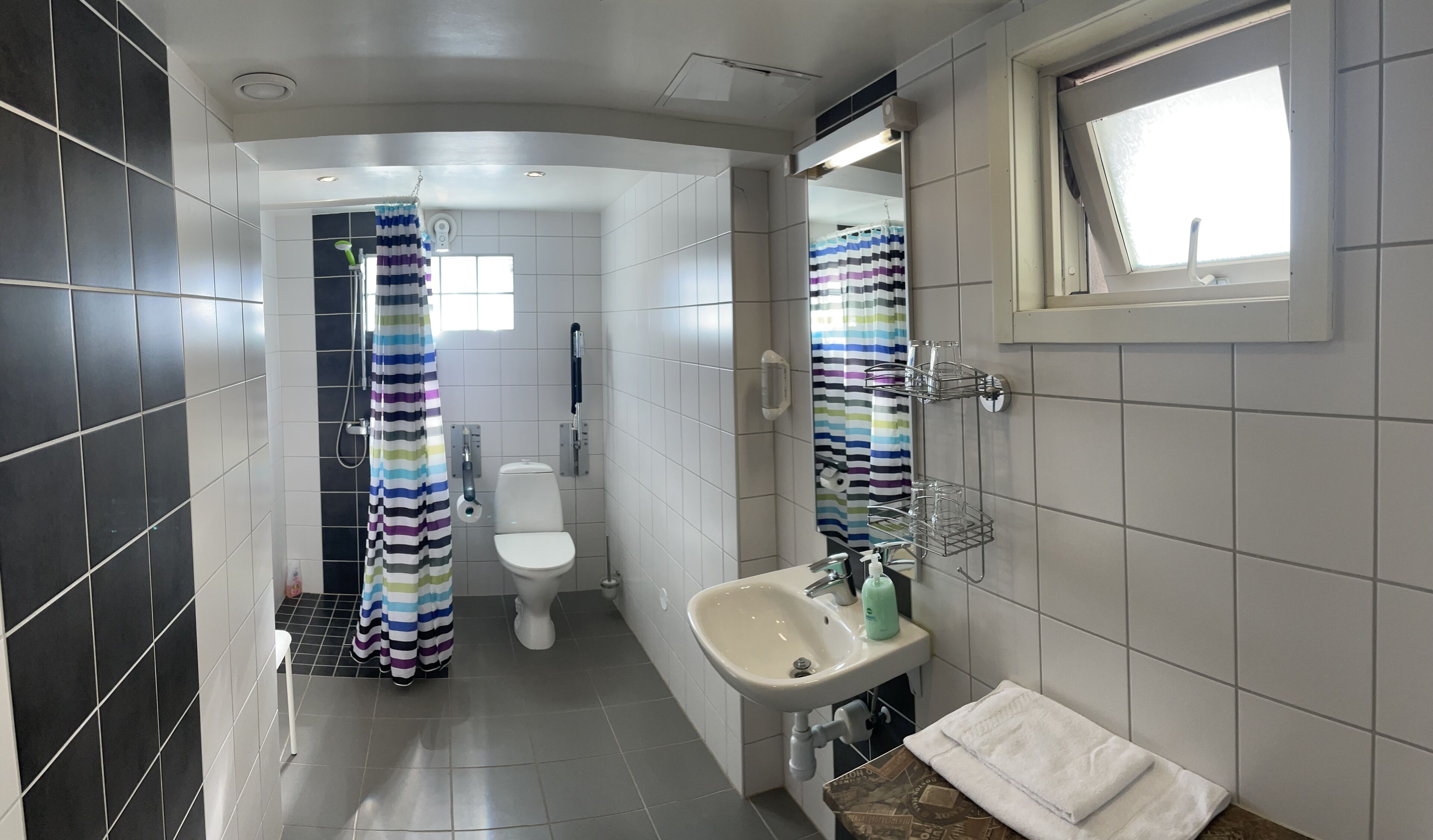 Un baño moderno con inodoro, lavamanos y zona de ducha.