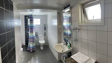 Un baño moderno con inodoro, lavamanos y zona de ducha.