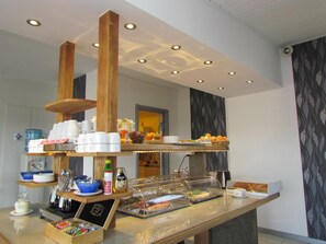 A buffet setup with various food items, utensils, and condiments. - Fleninge Classic Motel (Fleninge)