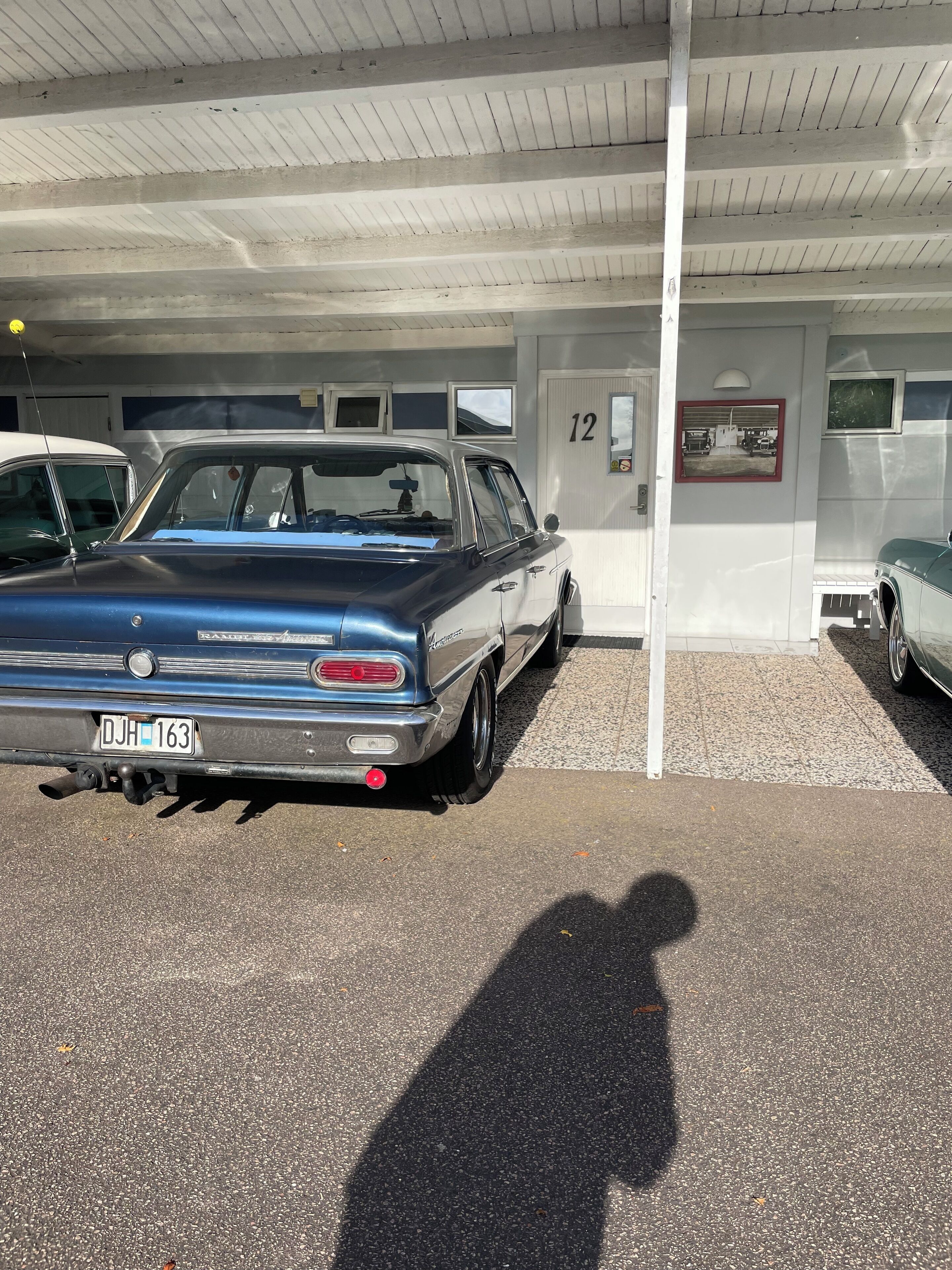 A parking garage with a blue car parked in a designated spot.