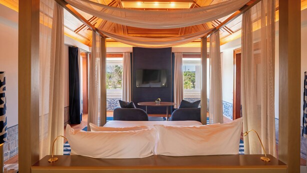 Una habitación con una cama, un televisor y una mesa con sillas.