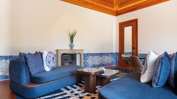Un salon moderne avec un canapé bleu, une table basse en bois et un tapis à motifs.