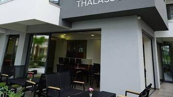 A modern building with the sign "OLYMPUS THALASSEA" indicating a hotel.