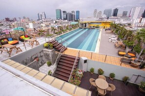 Ein Pool auf dem Dach mit Stadtansicht im Hintergrund.