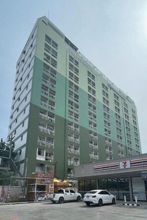 A multi-story building with a green facade and multiple windows. - Witchuwan Sport & Spa Apartel (Bangkok)