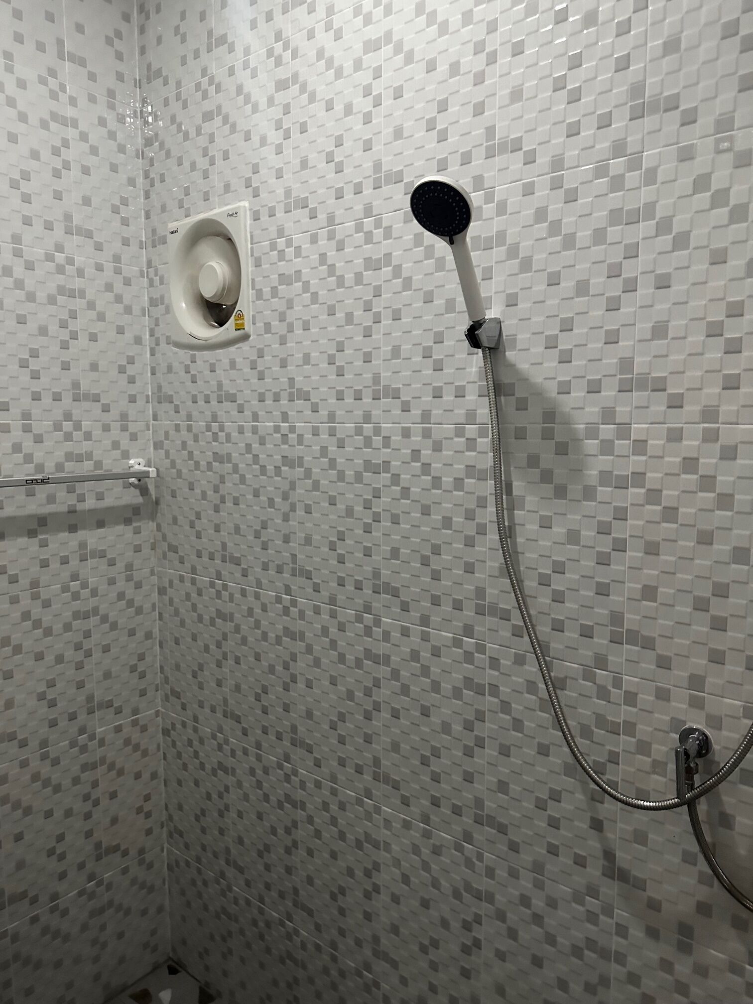 Ducha con cabezal de ducha de mano y grifo empotrado.