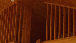 A wooden staircase leading to a loft area with a sloped ceiling and a light fixture on the wall. - Sjøholt Camping (Ålesund)