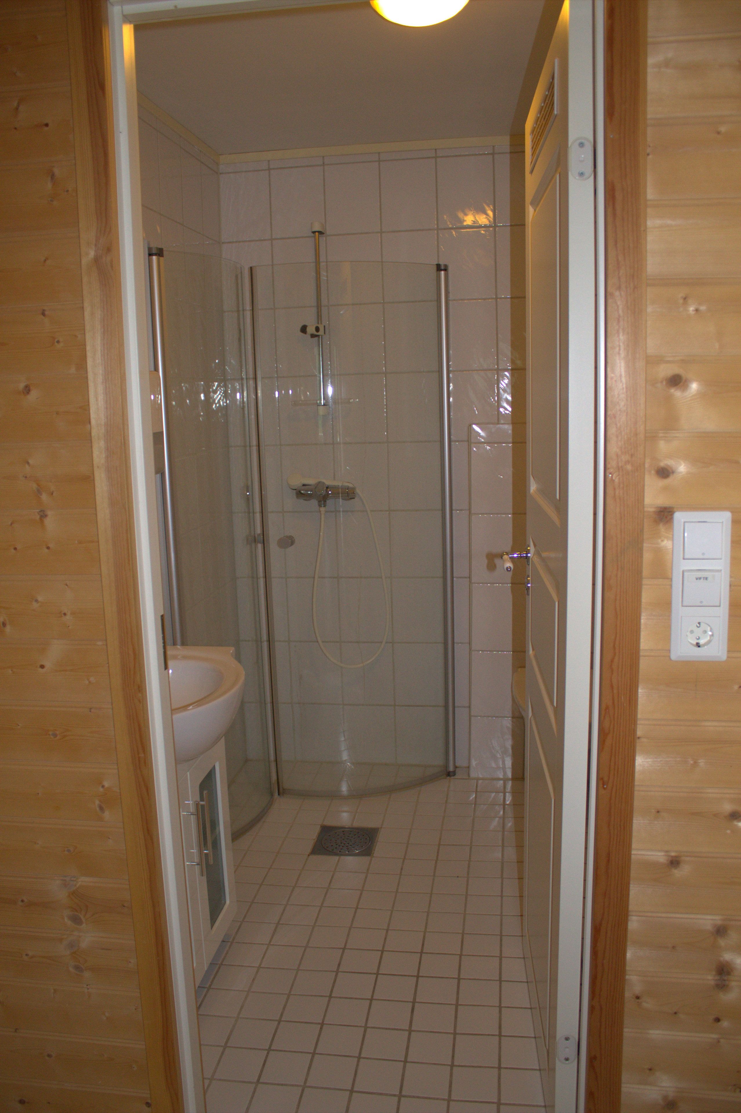 Un baño pequeño y privado con ducha, inodoro y lavamanos.