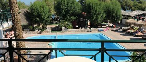 Una piscina al aire libre de temporada, sombrillas
