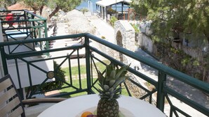 A balcony with a table, chairs, and a pineapple. - Troulakis Beach Hotel (Chania)