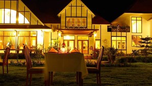 Una casa de dos pisos con un área de comedor al aire libre.