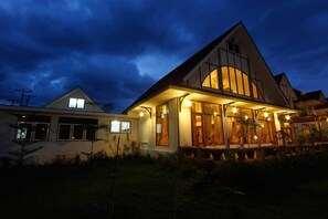 A modern house with a large front porch and a dining area.