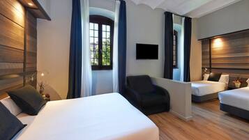 Habitación de hotel con dos camas, un televisor y una silla.