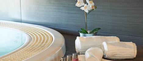 Un espace bien-être comprenant un jacuzzi, des serviettes et des articles de toilette.