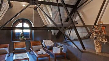 Acogedor dormitorio en ático con muebles de madera, un ventanal grande y un jarrón decorativo.