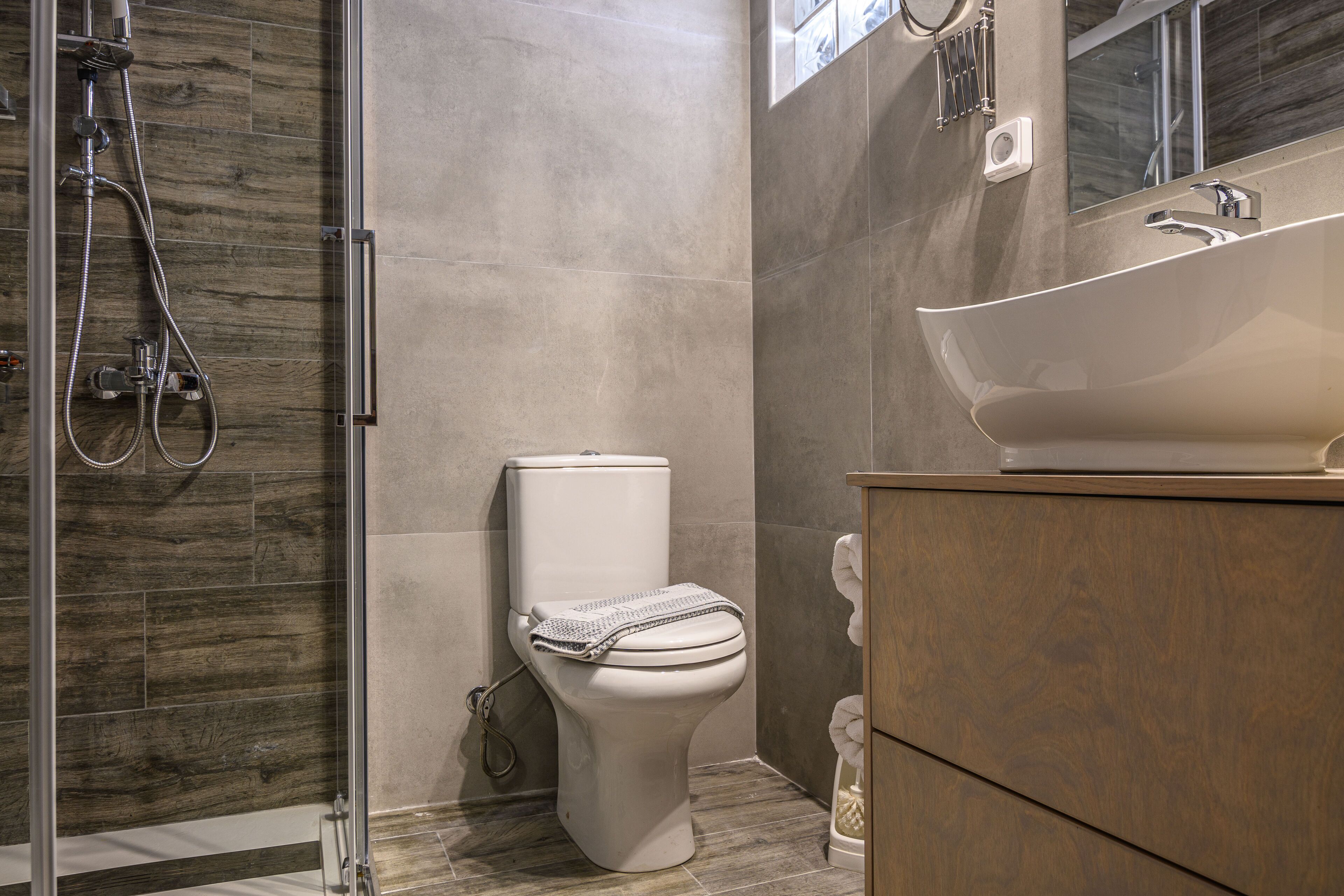 A modern bathroom with a shower, toilet, and vanity.