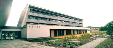 Un hôtel moderne doté d’un toit plat, de grandes fenêtres et d’une enseigne indiquant sa fonction.