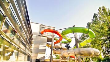 A water park with multiple slides and a building with large windows.