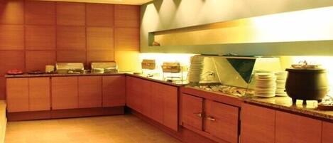 A modern kitchen with wooden cabinets, a countertop with stacked plates, and a large pot on the counter.